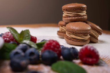 Hafif arka planda çikolatalı tatlılar, ahududu ve yaban mersinli. Noel şenliği arka planı