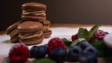 Hafif arka planda çikolatalı tatlılar, ahududu ve yaban mersinli. Noel şenliği arka planı