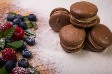 Hafif arka planda çikolatalı tatlılar, ahududu ve yaban mersinli. Noel şenliği arka planı