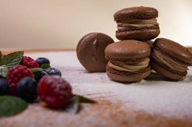 Hafif arka planda çikolatalı tatlılar, ahududu ve yaban mersinli. Noel şenliği arka planı