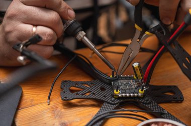 FPV insansız hava aracı parçasının lehimleme, montajlama, IC parçası insanlar tarafından birleştirildi. Yakın çekim, yüksek teknoloji.