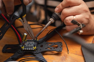 FPV insansız hava aracı parçasının lehimleme, montajlama, IC parçası insanlar tarafından birleştirildi. Yakın çekim, yüksek teknoloji.