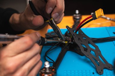 FPV insansız hava aracı parçasının lehimleme, montajlama, IC parçası insanlar tarafından birleştirildi. Yakın çekim, yüksek teknoloji.
