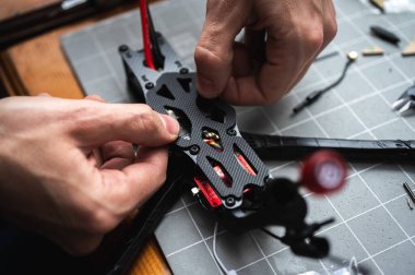 FPV insansız hava aracı parçasının lehimleme, montajlama, IC parçası insanlar tarafından birleştirildi. Yakın çekim, yüksek teknoloji.