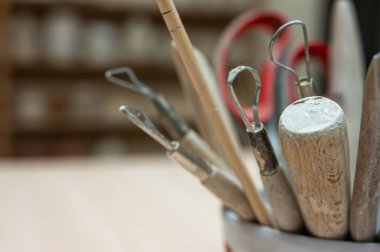 A set of tools for sculpting from clay in the workshop, at the workplace. Close up, place for inscription