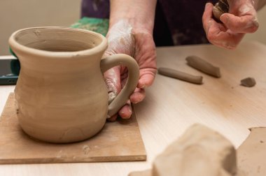 Clay, çömlek ya da el sanatları atölyesinde küçük işletme atölyesinde sanatsal bir bardak ya da kupa kalıbı üzerinde çalışıyor. Heykelde el işi ürünleri üreten yaratıcı sanatçı ya da işçilerin eli