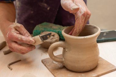 Clay, çömlek ya da el sanatları atölyesinde küçük işletme atölyesinde sanatsal bir bardak ya da kupa kalıbı üzerinde çalışıyor. Heykelde el işi ürünleri üreten yaratıcı sanatçı ya da işçilerin eli
