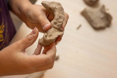 Clay, çömlek ya da el sanatları atölyesinde küçük işletme atölyesinde sanatsal bir bardak ya da kupa kalıbı üzerinde çalışıyor. Heykelde el işi ürünleri üreten yaratıcı sanatçı ya da işçilerin eli