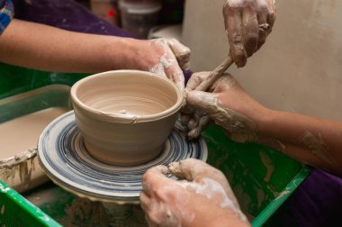 Clay, seramik ya da bir tasarım atölyesinde sanatsal bardak ya da kupa üzerinde çalışan eller. Heykel sanatı yapan yaratıcı bir sanatçı ya da işçinin eli