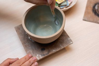 Clay, seramik ya da bir tasarım atölyesinde sanatsal bardak ya da kupa üzerinde çalışan eller. Heykel sanatı yapan yaratıcı bir sanatçı ya da işçinin eli
