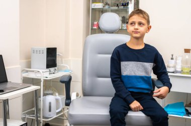 Küçük bir çocuk, sarışın bir genç, muayene için otolaryngolojistin ofisinde oturuyor, korkuyor, elleriyle ve korkuyla kendinden uzaklaştırıyor. Yazmak için yer