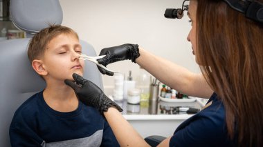 Burun muayenesi, küçük çocuk, sarışın genç endişeli, otoların ofisinde oturuyor, doktordaki burun deliklerini inceliyor, duygusal. Tedavi ilaçları