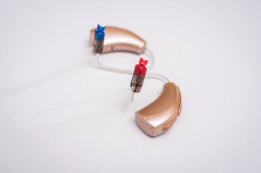 İşitme cihazı beyaz arkaplanda izole edilmiş. Yakın çekim, sağırlar için işitme cihazı