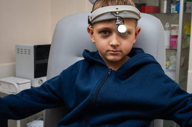 Küçük duygusal çocuk, sarışın ergen, otolaringolojistin ofisinde oturuyor, muayene için doktoru bekliyor, ama gülümsüyor. Fiziksel muayene.