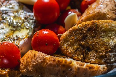 Sebzeli camembert peyniri, kiraz domatesleri, baharatlar, ekmek, kızarmış ekmek ve sarımsak.