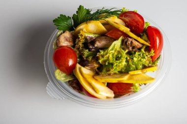 Yaz salatası, domates salatası, sebzeler, plastik bir kabın içinde arka planda yemek teslimatı, hazır yemek.