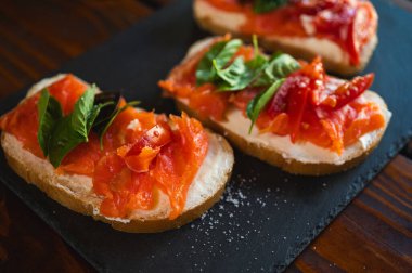 Lezzetli kırmızı balık kanepeleri, kırmızı domatesli beyaz ekmek, koyu arka plan, seçici odak, kanepe, hızlı atıştırmalık.