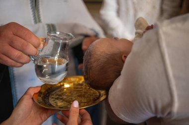 Bir çocuğun vaftiz edilmesi, kilisede bir çocuğun kafasına su serpmek.