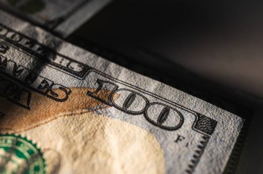 Detaylar, güvenlik özellikleri ve canlı renklerle dolu 100 dolarlık banknota yakından bakın. Finans, bankacılık ve zenginlik temsil teması, düşük anahtar, seçici odaklanma