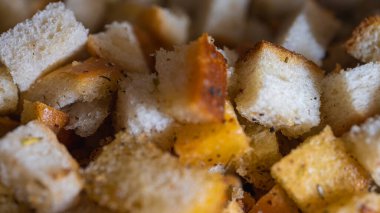 Bitkilerle tatlandırılmış altın sarısı kıtır ekmekler leziz bir doku ve çıtır çıtır yaratır. Yemek pişirmek, yemek tarifleri ya da yemek arkaplanı için mükemmel yakın çekim ekmek küpleri.