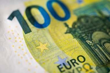Güvenlik unsurları ve karmaşık tasarımı gösteren 100 avroluk net bir tasarıya yakın plan. Para, zenginlik, finans, bankacılık ve Avrupa para birimi gibi konular için kullanışlı