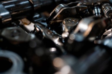Hareket halindeki endüstriyel metal dişlilerin yakın görüntüsü, mühendisliği, makine yapımını, makine yapımı ve hassas imalatını, parçalanmış araba motorunu, yedek parçaları sembolize ediyor. Seçici odak
