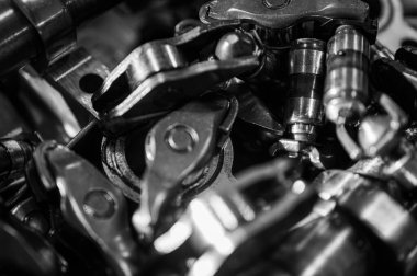 Metal dişliler ve mekanik parçaların siyah ve beyaz yakın plan görüntüleri endüstriyel ekipmanları, hassas mühendisliği ve mekanik süreçleri sembolize ediyor.