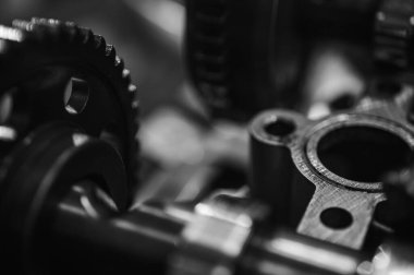 Metal dişliler ve mekanik parçaların siyah ve beyaz yakın plan görüntüleri endüstriyel ekipmanları, hassas mühendisliği ve mekanik süreçleri sembolize ediyor.