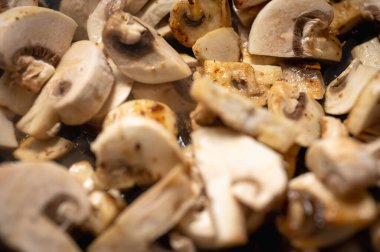 Taze sotelenmiş, altın sarısı kenarlı mantarların yakın çekimi. Lezzetli, sağlıklı yemek malzemeleri, vegan yemekleri ve gurme tarifleri. Makro yemek fotoğrafçılığı