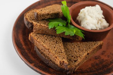 Geleneksel çavdar ekmeği dilimlenmiş, domuz yağı ve taze maydanozla seramik tabakta serpiştirilmiş. Orijinal Doğu Avrupa mutfağı, yakın çekim, üst görüş, yan görüş