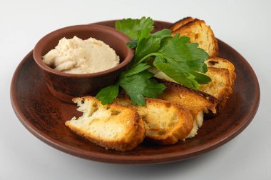 Geleneksel köy mezeleri, domuz pastırmalı kızarmış beyaz ekmek dilimleri ve seramik tabakta taze maydanoz. Orijinal Doğu Avrupa mutfağı, yakın çekim, üst görüş, yan görüş