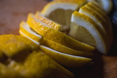 Keskin bir bıçakla tahta kesme tahtasının üzerinde taze kesilmiş limon. Parlak turunçgil meyvesi, C vitamini bakımından zengin, yemek, içki ve sağlıklı yaşam tarzı için ideal, virüs önleme, seçici odaklanma