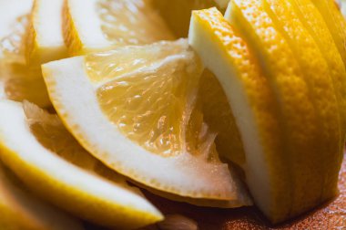 Keskin bir bıçakla tahta kesme tahtasının üzerinde taze kesilmiş limon. Parlak turunçgil meyvesi, C vitamini bakımından zengin, yemek, içki ve sağlıklı yaşam tarzı için ideal, virüs önleme, seçici odaklanma