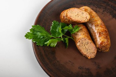 Köy seramik tabağında taze maydanozlu ev yapımı sosis. Kızarmış altın kabuklu ve sulu dolgulu geleneksel yemek. Lezzetli yemek fotoğrafçılığı