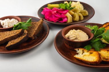Geleneksel Doğu Avrupa mutfağı kırsal kil tabaklarda servis edilir. Etler, patatesler, krepler, hamur tatlısı ve hafif arka planda ızgara sebzeler dahil olmak üzere çeşitli ev yapımı yemekler