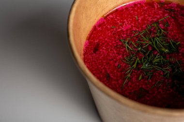 Geleneksel Ukrayna pancar çorbası ve taze dereotu yakından. Parlak kırmızı renk, doğal malzemeler, köy tarzı. Gerçek Slav mutfağı, hafif arka plandaki el sanatları yemeklerinde sağlıklı ve sağlıklı.