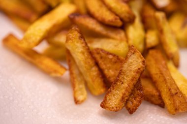 Deniz tuzu serpiştirilmiş altın çıtır patatesler, yakın plan. Mükemmel konforlu yemek konsepti, fast food menüleri, reklamlar ve yemek blogları için mükemmel, seçici odaklanma