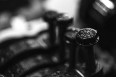 Metal otomobil motor parçaları ve mekanik detaylardan oluşan siyah-beyaz yakın çekim endüstriyel ekipmanları, hassas mühendisliği ve mekanik süreçleri sembolize ediyor, seçici odaklanma