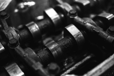 Metal otomobil motor parçaları ve mekanik detaylardan oluşan siyah-beyaz yakın çekim endüstriyel ekipmanları, hassas mühendisliği ve mekanik süreçleri sembolize ediyor, seçici odaklanma