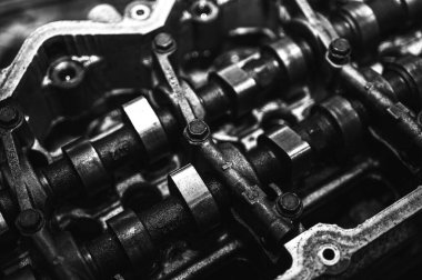 Metal otomobil motor parçaları ve mekanik detaylardan oluşan siyah-beyaz yakın çekim endüstriyel ekipmanları, hassas mühendisliği ve mekanik süreçleri sembolize ediyor, seçici odaklanma