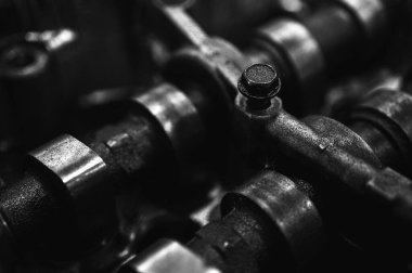 Metal otomobil motor parçaları ve mekanik detaylardan oluşan siyah-beyaz yakın çekim endüstriyel ekipmanları, hassas mühendisliği ve mekanik süreçleri sembolize ediyor, seçici odaklanma