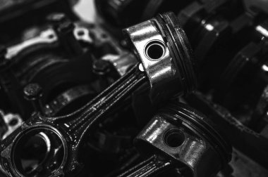 Metal otomobil motor parçaları ve mekanik detaylardan oluşan siyah-beyaz yakın çekim endüstriyel ekipmanları, hassas mühendisliği ve mekanik süreçleri sembolize ediyor, seçici odaklanma