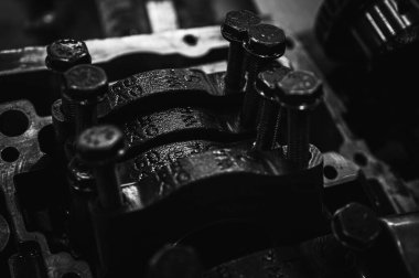 Metal otomobil motor parçaları ve mekanik detaylardan oluşan siyah-beyaz yakın çekim endüstriyel ekipmanları, hassas mühendisliği ve mekanik süreçleri sembolize ediyor, seçici odaklanma