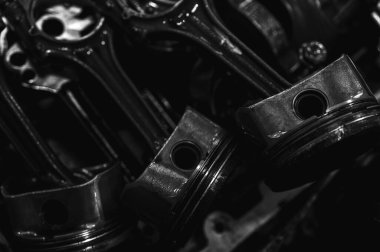 Metal otomobil motor parçaları ve mekanik detaylardan oluşan siyah-beyaz yakın çekim endüstriyel ekipmanları, hassas mühendisliği ve mekanik süreçleri sembolize ediyor, seçici odaklanma