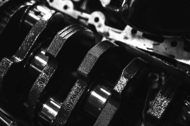 Metal otomobil motor parçaları ve mekanik detaylardan oluşan siyah-beyaz yakın çekim endüstriyel ekipmanları, hassas mühendisliği ve mekanik süreçleri sembolize ediyor, seçici odaklanma