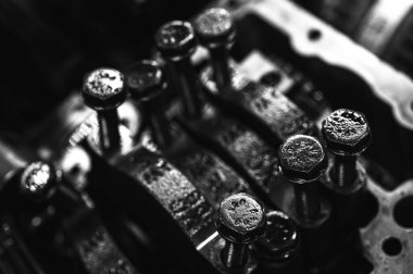 Metal otomobil motor parçaları ve mekanik detaylardan oluşan siyah-beyaz yakın çekim endüstriyel ekipmanları, hassas mühendisliği ve mekanik süreçleri sembolize ediyor, seçici odaklanma