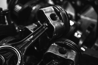 Metal otomobil motor parçaları ve mekanik detaylardan oluşan siyah-beyaz yakın çekim endüstriyel ekipmanları, hassas mühendisliği ve mekanik süreçleri sembolize ediyor, seçici odaklanma