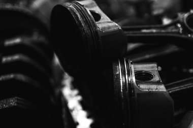 Metal otomobil motor parçaları ve mekanik detaylardan oluşan siyah-beyaz yakın çekim endüstriyel ekipmanları, hassas mühendisliği ve mekanik süreçleri sembolize ediyor, seçici odaklanma