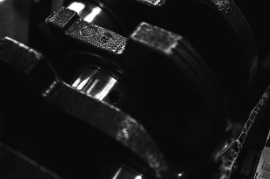 Metal otomobil motor parçaları ve mekanik detaylardan oluşan siyah-beyaz yakın çekim endüstriyel ekipmanları, hassas mühendisliği ve mekanik süreçleri sembolize ediyor, seçici odaklanma