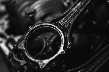 Metal otomobil motor parçaları ve mekanik detaylardan oluşan siyah-beyaz yakın çekim endüstriyel ekipmanları, hassas mühendisliği ve mekanik süreçleri sembolize ediyor, seçici odaklanma